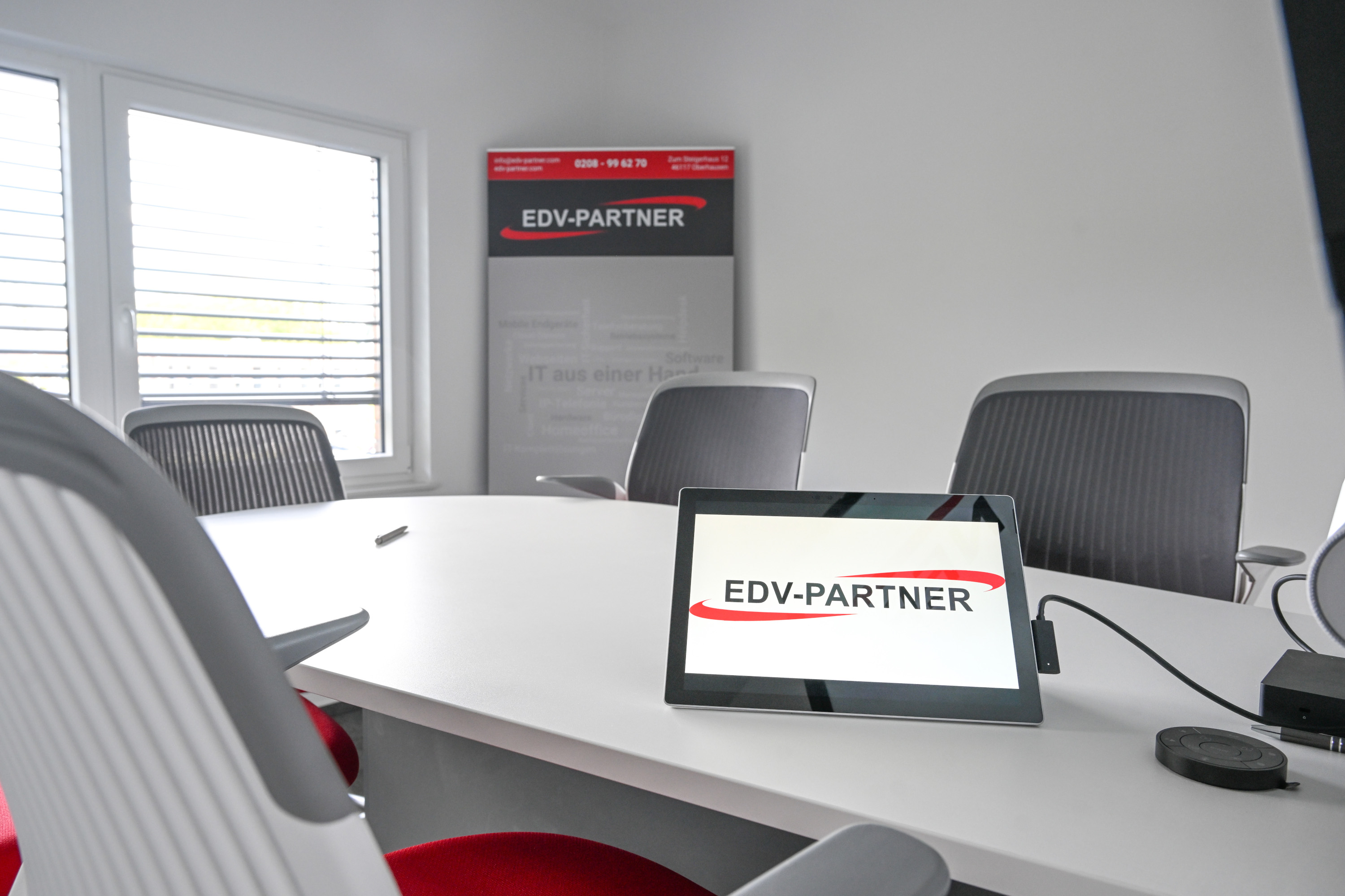 Zu sehen ist ein Foto vom Beratungsraum der EDV-PARTNER GmbH. Ein Surface ist an einem großen Monitor angeschlossen und das Logo der EDV-PARTNER GmbH ist geöffnet.