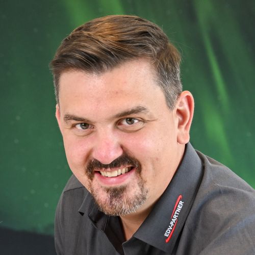 Man sieht ein freundlichen Herrn der mit einem Lächeln in die Kamera blickt.