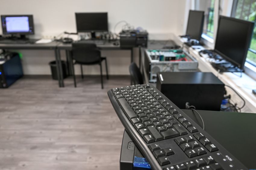 Nahaufnahme einer Tastatur, die auf einem Rechner an einem Arbeitsplatz in einer IT-Werkstatt liegt.